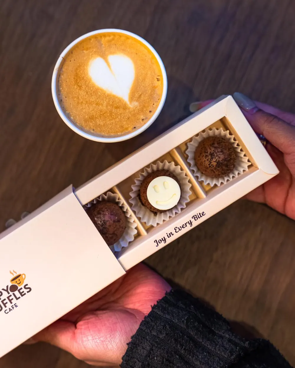 An open box of truffles with a latte